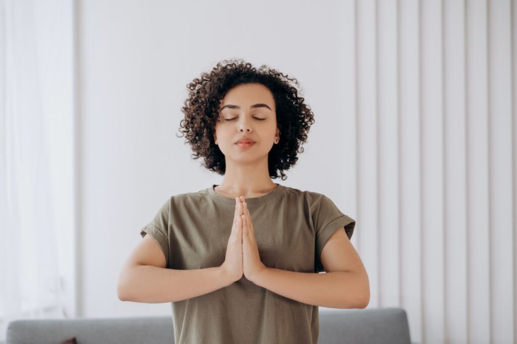 Bij namaste houd je je handen tegen elkaar en tegen je borst,
